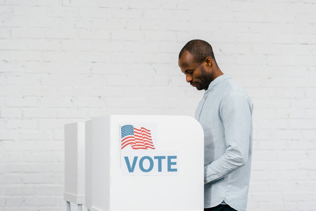 african american citizen voting near stand with vote lettering