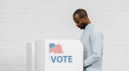 african american citizen voting near stand with vote lettering