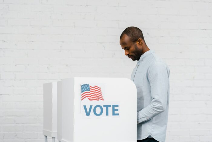 african american citizen voting near stand with vote lettering after getting ohio voting information